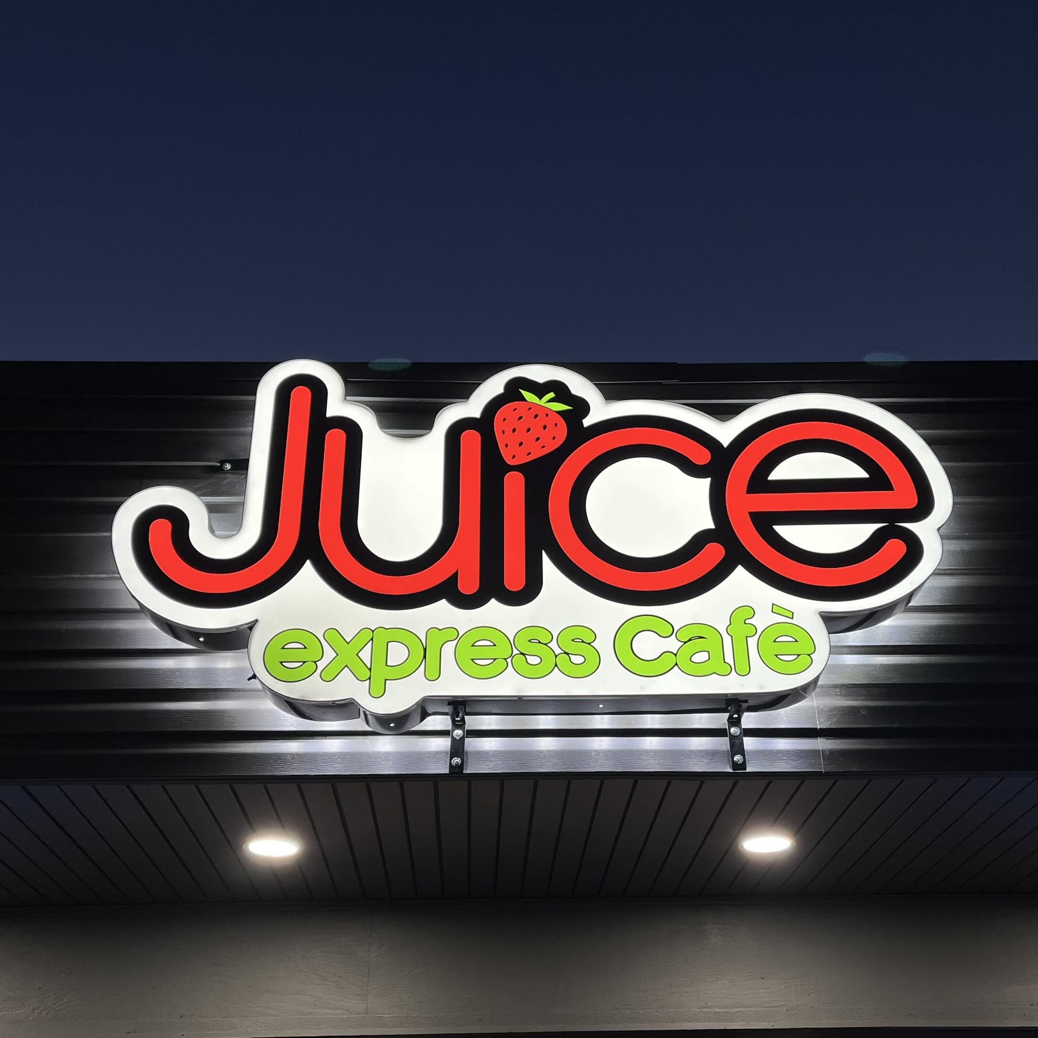 Close-up of the Juice Express Café sign with red lettering and a strawberry